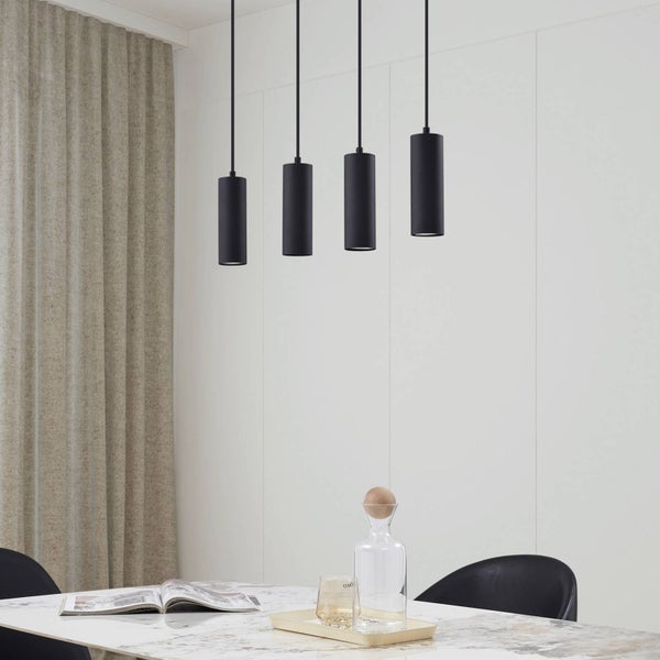 Vier schwarze Pendelleuchten über einem Esstisch