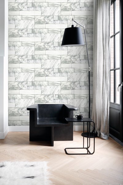 Wohnzimmer mit Tapete in Steinoptik, Sessel und Stehlampe