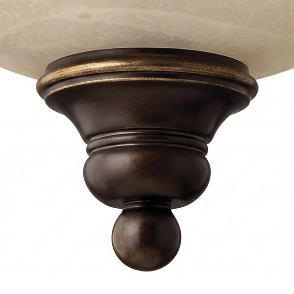 Detailaufnahme einer Deckenleuchte mit bronzefarbenem Metallsockel und Lampenschirm.