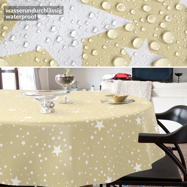 Runde wasserabweisende Tischdecke mit Sternenmuster auf einem Tisch im Wohnzimmer mit Detailansicht von Wassertropfen auf der Oberfläche.