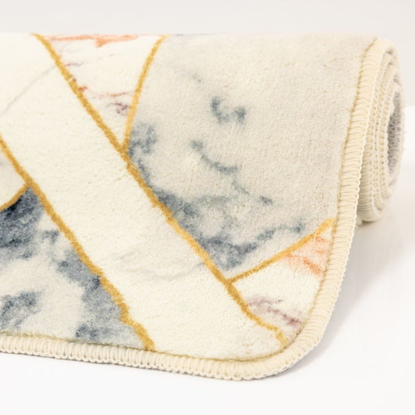 Zusammengerollter Teppich mit Marmor-Optik, geometrischen Linien und gekettelter Kante.