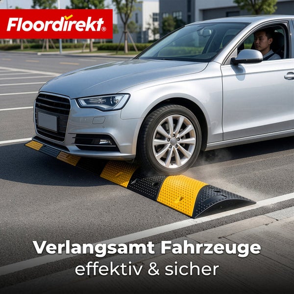 Silbernes Auto auf einer modularen Fahrbahnschwelle aus schwarzen und gelben Gummielementen zur Verkehrsberuhigung auf Asphalt. Floordirekt Logo.