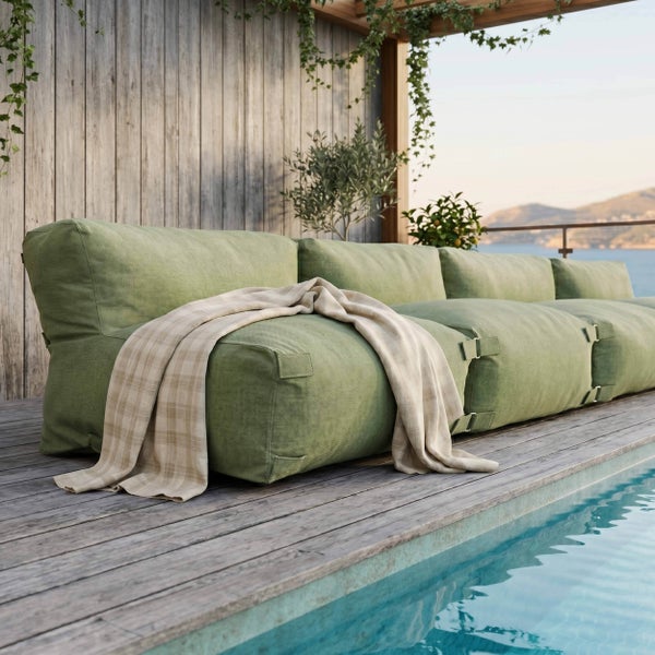 Grünes modulares Outdoor-Loungesofa mit Decke auf einer Holzterrasse am Pool mit Blick auf das Meer.
