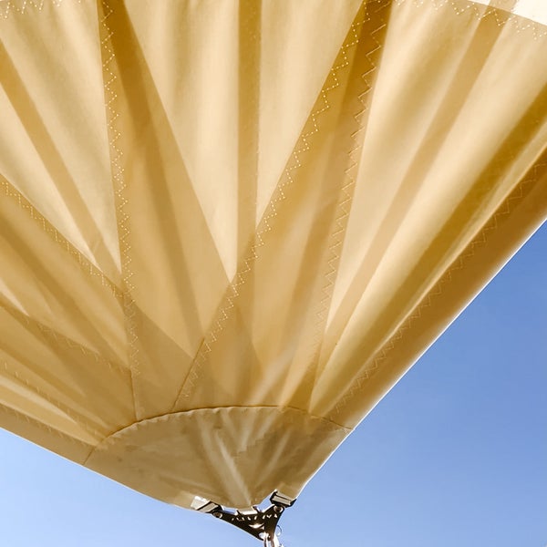 Detailaufnahme eines sandfarbenen Sonnensegels mit verstaerkter Ecke und Zickzack-Naehten.
