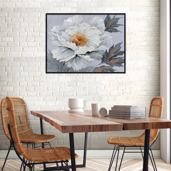 Wandbild mit abstraktem Blumenmotiv in einem Esszimmer mit Holztisch und Rattan Stühlen vor einer Backsteinwand.