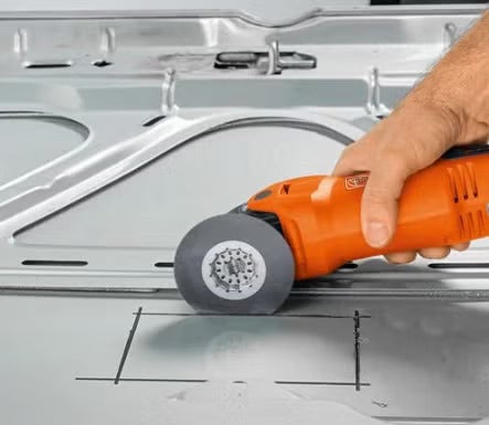 Ein elektrisches Fein Multitool beim Schneiden eines Rechtecks in eine Metalloberfläche.