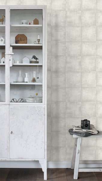 Szene mit weißer Mustertapete, einem Schrank und einer Bank mit Dekorationsgegenständen