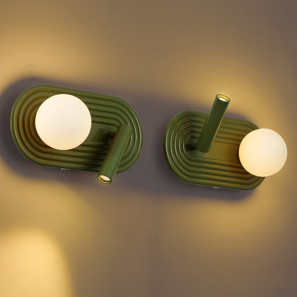 Zwei Wandleuchten mit ovaler, gerippter Basis und einer Kombination aus einer Glaskugel und einem verstellbaren LED Lesestrahler.