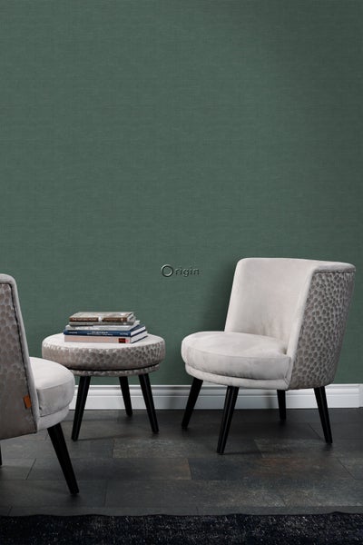 Szene mit zwei Sesseln, einem Beistelltisch und einer grünen strukturierten Tapete