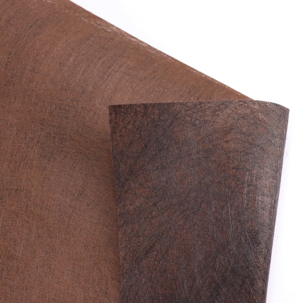 Nahaufnahme eines braunen Unkrautvlieses als Beetabdeckung