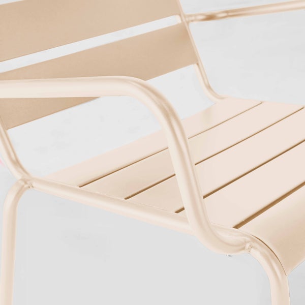 Nahaufnahme eines beigen Gartenstuhls aus Metall mit Lamellensitz und geschwungenen Armlehnen.