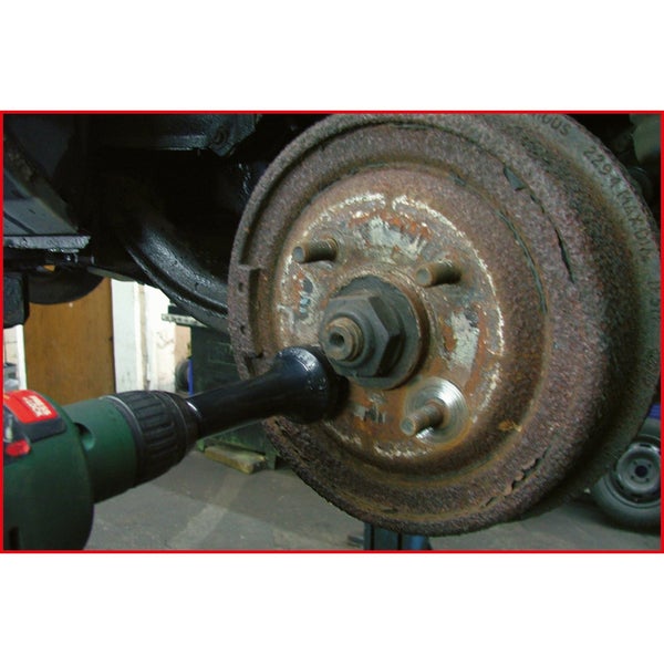 Eine Bohrmaschine mit Steckschlüsselaufsatz wird verwendet, um die Radmutter an einer Autoradbremse zu lösen.