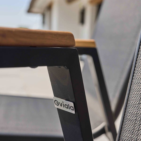 Nahaufnahme eines Gartenstuhls mit Metallgestell und einer Armlehne aus Holz sowie dem Oviala Logo.