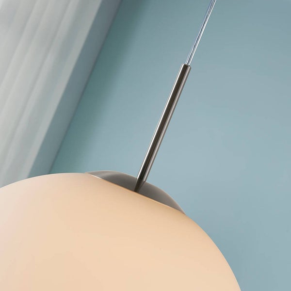 Nahaufnahme einer Pendelleuchte mit rundem Glasschirm und einer Aufhängung aus Metall.