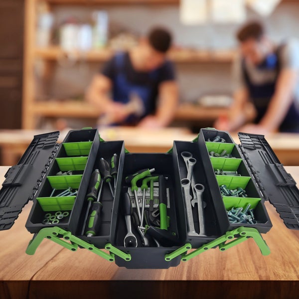 Geöffneter Werkzeugkoffer aus Kunststoff mit Schraubendrehern, Gabelschlüsseln und Kleinteilen in grünen Fächern auf einer Werkbank.