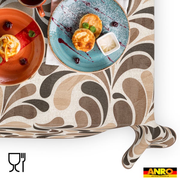 Abwaschbare Tischdecke mit abstraktem Tropfenmuster in Braun und Beige, gedeckt mit Speisen. Lebensmittelecht. ANRO Deutsche Manufaktur Logo.