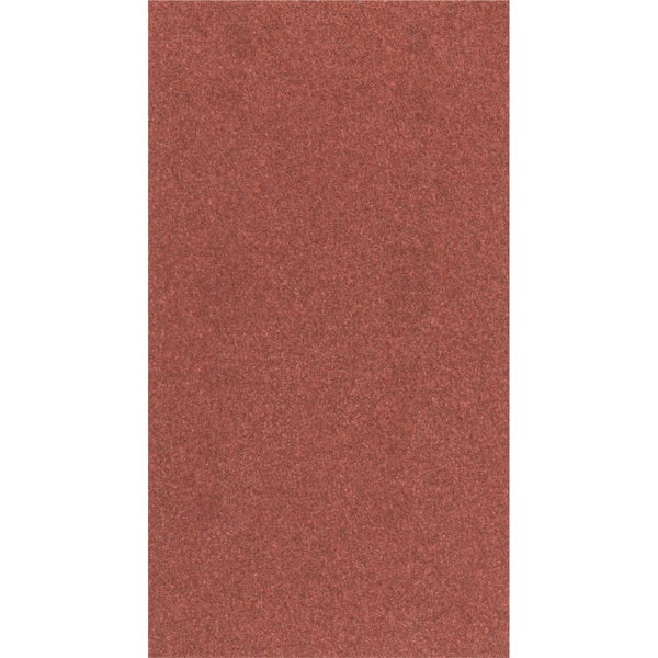 Eine Person schneidet eine Tapetenrolle mit einer Schere auf einem Tisch zu.