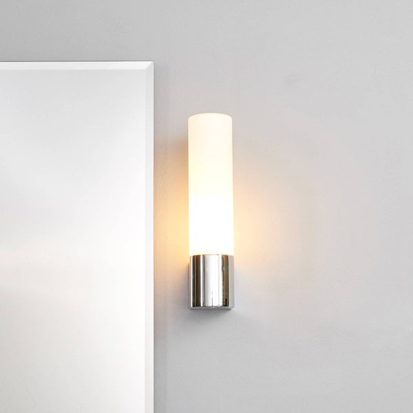 Wandleuchte aus Metall und Glas neben einem Spiegel