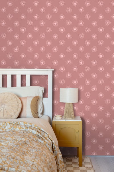 Schlafzimmer mit Bett, Nachttisch und Tapete mit Sonne- und Mondmotiven