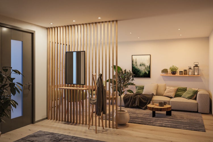 Moderner Wohnraum mit Raumteiler aus Holzlamellen, hellem Sofa, Couchtisch aus Holz und Zimmerpflanzen.