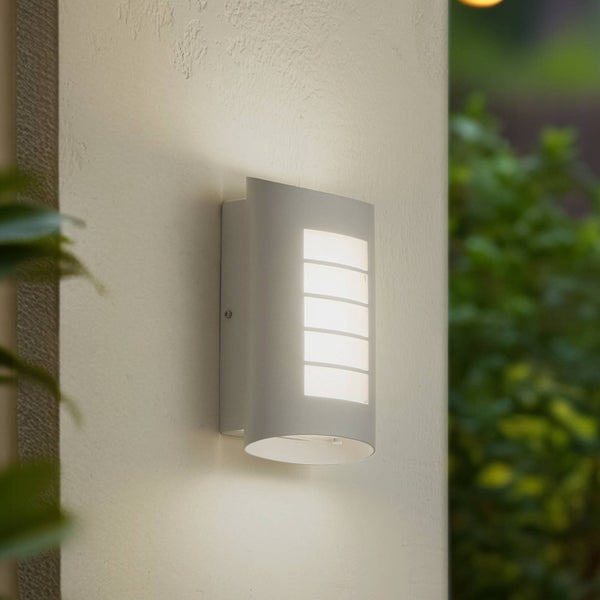Moderne Außenwandleuchte an einer Hauswand mit fünf Lichtschlitzen und Lichtaustritt nach oben und unten.