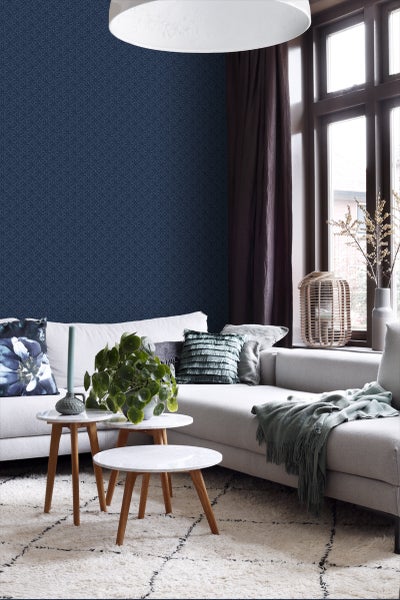 Wohnzimmer mit Couch, Beistelltischen und gemusterter Tapete