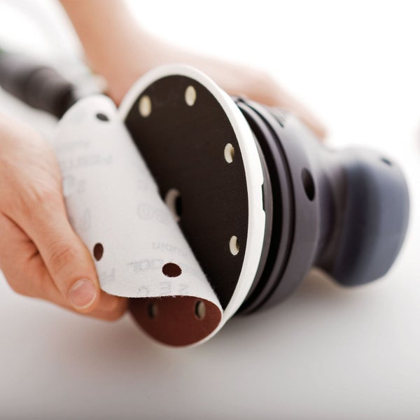 Detailaufnahme eines Exzenterschleifers beim Wechseln des Schleifpapiers.