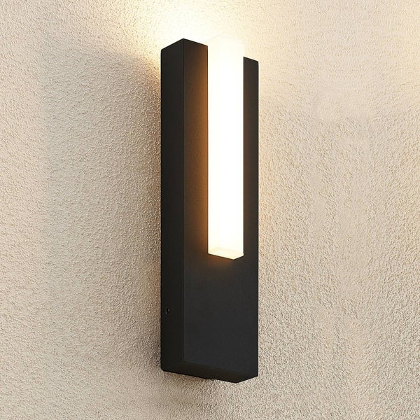 Moderne schwarze LED-Wandleuchte in rechteckiger Form mit weißem Lichtelement, eingeschaltet an einer strukturierten Wand montiert.