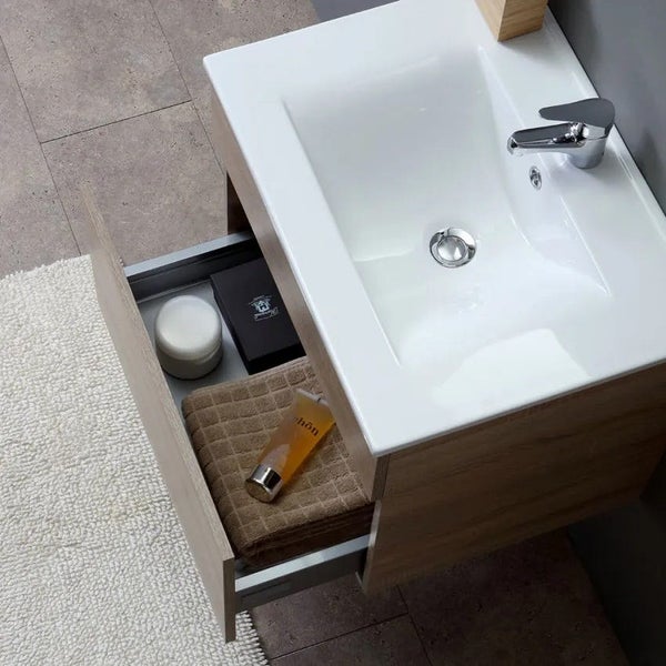 Waschtisch mit Unterschrank in Holzoptik und geöffneter Schublade mit Handtuch und Badezimmerutensilien in modernem Badezimmer.
