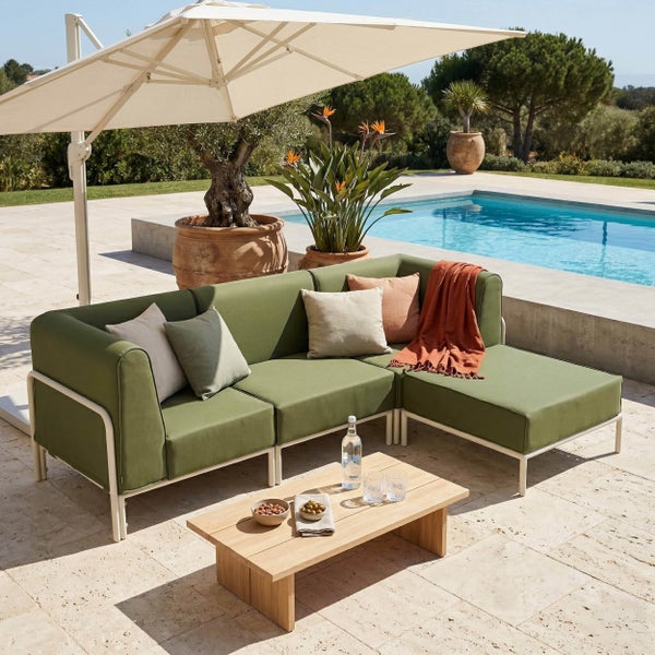 Outdoor-Lounge-Set mit grünem Ecksofa, Holztisch und Ampelschirm auf einer hellen Terrasse am Pool.