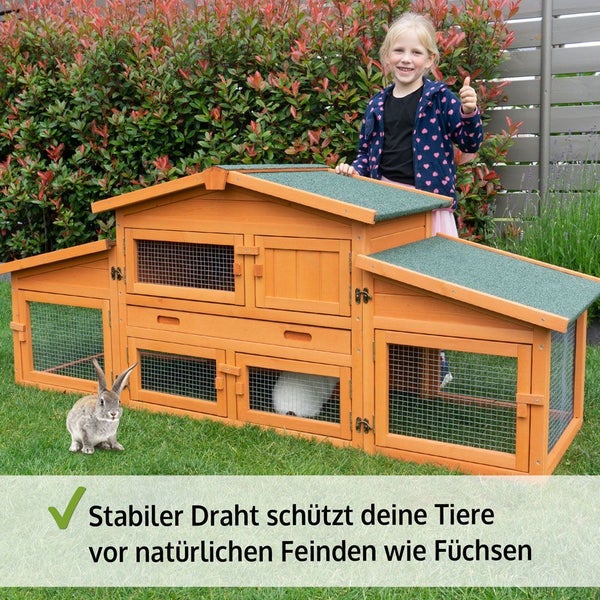 Großer Kaninchenstall aus Holz mit mehreren Etagen, stabilen Drahtgittern und Bitumendach im Garten mit einem Kind und Kaninchen.
