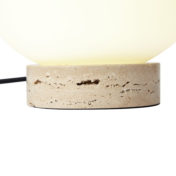 Tischleuchte mit rundem Sockel in Steinoptik und warm leuchtendem, kugelförmigem Schirm.