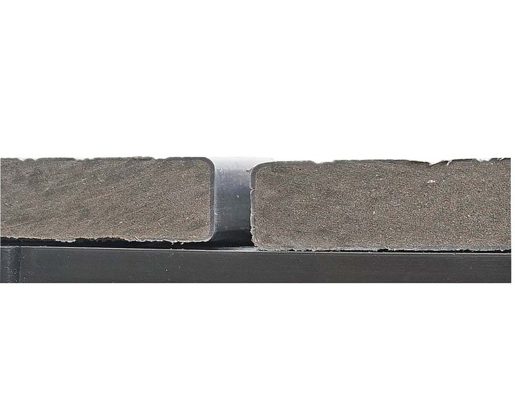 Detailansicht der Fuge und des Querschnitts von zwei Terrassendielen aus Holz-Kunststoff-Verbundwerkstoff auf einer Unterkonstruktion.
