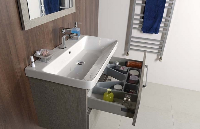 Badezimmer mit Waschtischunterschrank, Waschbecken und offenem Schubladeneinsatz zur Aufbewahrung von Badutensilien