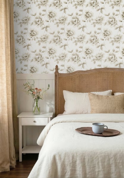 Vliestapete mit floralem Rosenmuster in einem hellen Schlafzimmer mit Holzbett, weißem Nachttisch und beigen Vorhängen.