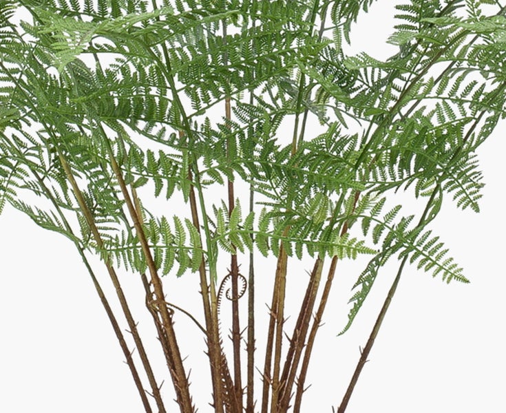 Detailansicht einer künstlichen Monstera Pflanze mit großen grünen Blättern und charakteristischen Einschnitten.