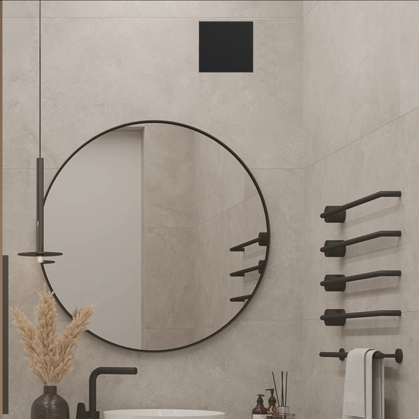 Modernes, organisiertes Badezimmer mit rundem Spiegel, mattschwarzen Handtuchhaltern und weißem Waschbecken vor hellgrau strukturierten Fliesen.