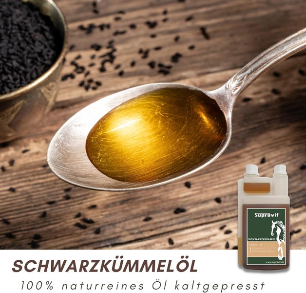 Schwarzkümmelöl in einem Löffel und Schwarzkümmelsamen in einer Schale neben einer Flasche Schwarzkümmelöl