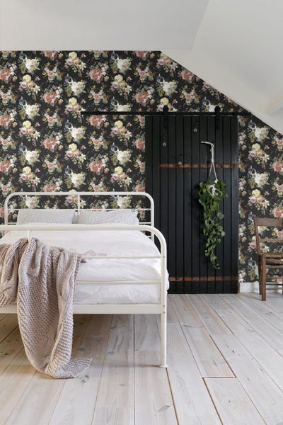 Schlafzimmer mit weißem Bett, Blumendrucktapete und dunkler Schiebetür