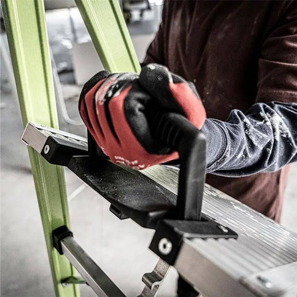 Hand mit Arbeitshandschuh greift den schwarzen Tragegriff einer Aluminiumleiter mit grünen Holmen.