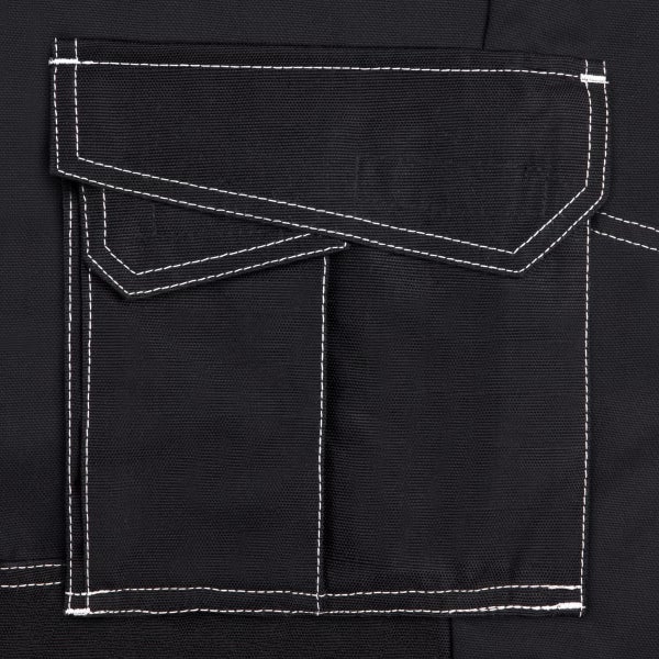 Detailaufnahme einer Tasche an Arbeitskleidung mit Kontrastnähten und verstärkten Kanten aus robustem Baumwollgewebe.
