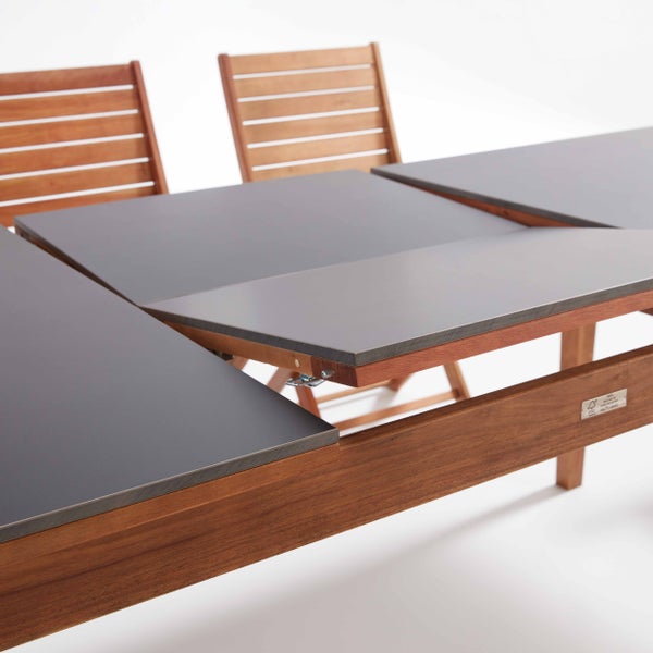 Nahaufnahme von Gartenmöbeln bestehend aus einem Tisch mit Marmordekor und weißem Gestell sowie einem hellgrünen Stuhl auf einer Holzterrasse.