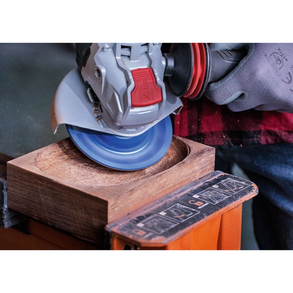 Einhandwinkelschleifer bearbeitet ein Holzstück.