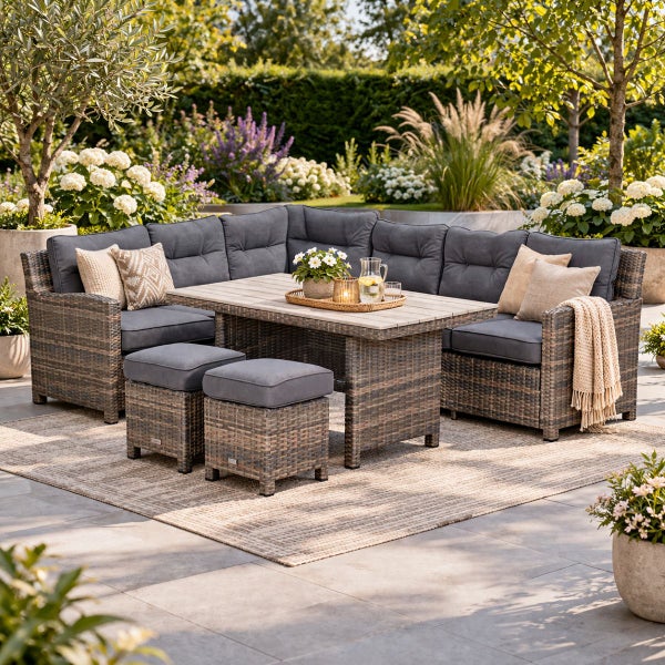 Garten Lounge Set aus Polyrattan mit Ecksofa, zwei Hockern und Holztisch, dunkelgraue Polster, in einem hellen Garten.