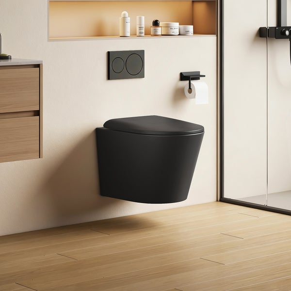 Wand-WC in Mattschwarz mit passender Drückerplatte und Toilettenpapierhalter in einem modernen Badezimmer mit Holzoptik.