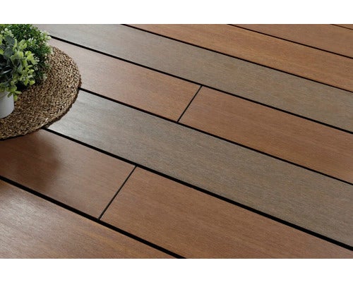Terrassendielen mit Holzstruktur in verschiedenen Brauntönen, im Außenbereich verlegt neben einer dekorativen Pflanze.