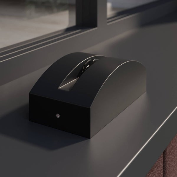 Dunkelgraue, gewölbte LED Fensterbankleuchte zur Fassadenbeleuchtung auf einer Fensterbank montiert.