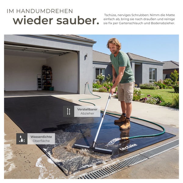 Mann reinigt eine wasserdichte tectake Garagenbodenmatte mit einem verstellbaren Bodenabzieher und einem Gartenschlauch auf einer Einfahrt.