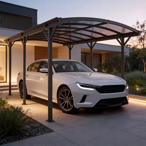 Moderner Carport aus grauem Aluminium mit gebogenem, lichtdurchlässigem Dach über einem weißen Auto auf einer organisierten, hell beleuchteten Einfahrt.