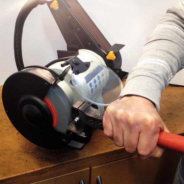 Person schleift Werkzeug an einer Schleifmaschine